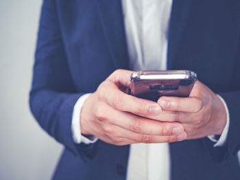 Midsection of man using mobile phone