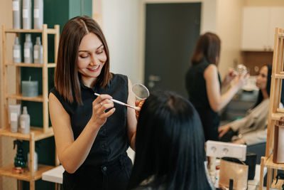 The makeup artist works in her salon, applies professional makeup. beauty industry, make-up