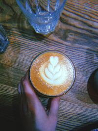 Hand holding coffee cup on table