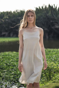 Portrait of young woman standing on field