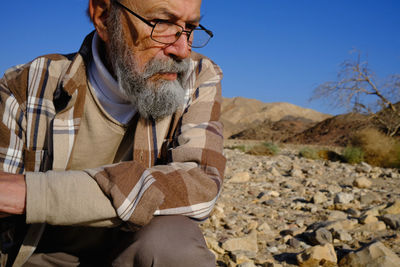 Senior man looking down in the desert 