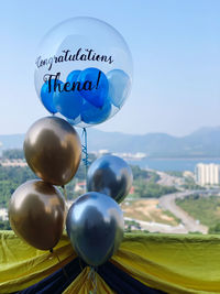 Close-up of balloons against blue sky