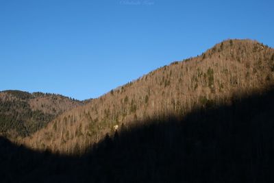 Scenic view of mountains against clear blue sky