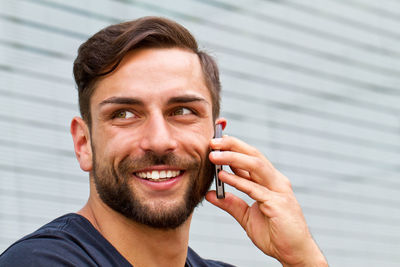 Close-up portrait of young man using smart phone