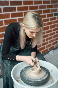 Woman making pottery in workshop