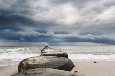 Scenic view of rocks on beach against sky