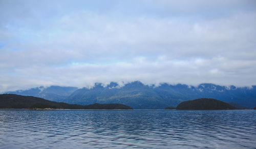 Scenic view of sea and mountains against sky