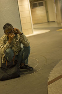 Midsection of woman sitting by building