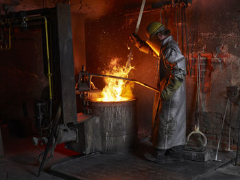 Industry, worker at furnace during melting copper, wearing a fire proximity suit