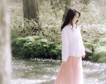 Rear view of young woman standing in lake