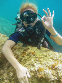 Portrait of scuba diver showing ok sign in sea