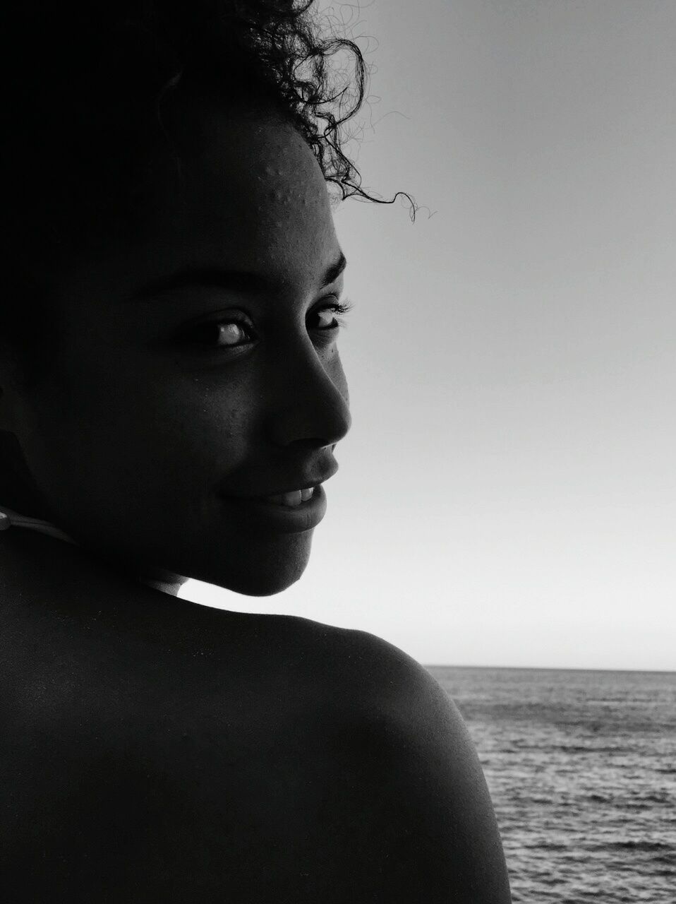 headshot, person, lifestyles, water, sea, close-up, head and shoulders, leisure activity, young adult, looking at camera, portrait, focus on foreground, front view, human face, copy space, clear sky, contemplation