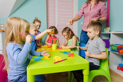 Rear view of people sitting on table