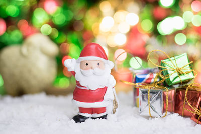 Close-up of figurine on snow covered christmas tree during winter