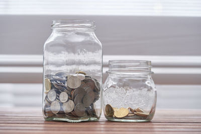 Close-up of coins in jars on table