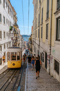 People walking on street amidst buildings in city