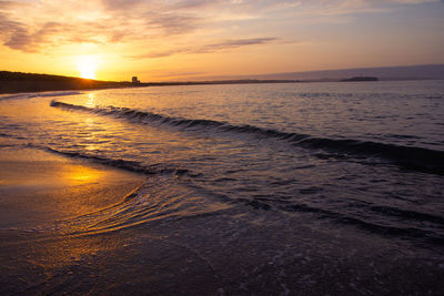 Scenic view of beach against sky during sunset