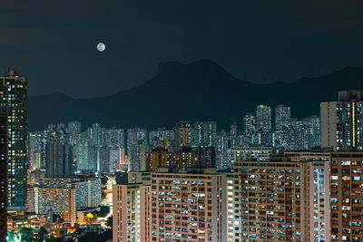 Illuminated buildings in city against sky at night