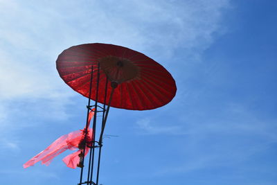 Low angle view of red flag against sky