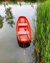 Red boat moored at lake