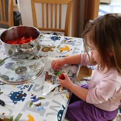 High angle view of cute girl cleaning strawberry on table at home