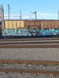 Graffiti on railroad tracks against sky