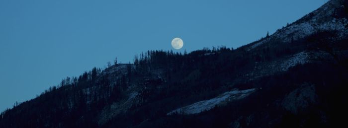 Low angle view of mountains against clear sky at night