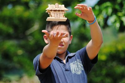 Boy catching model home on sunny day