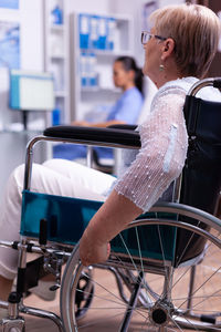 Rear view of woman sitting on wheelchair