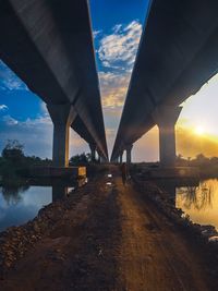 Bridge over river against sky during sunset