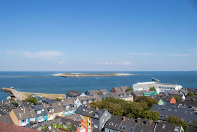 High angle view of buildings and sea against sky