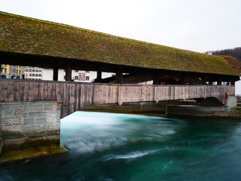 Bridge over river against buildings