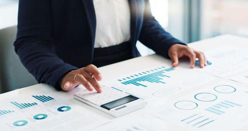 Midsection of businessman working on table