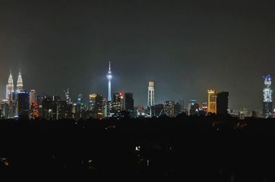 Illuminated cityscape against sky at night