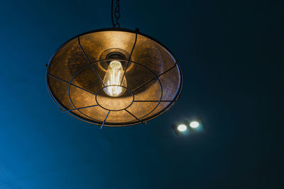 Low angle view of illuminated pendant light hanging from ceiling