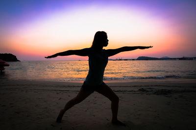 Silhouette person on beach against sky during sunset