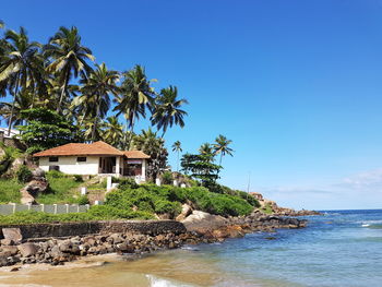 House by sea against clear blue sky