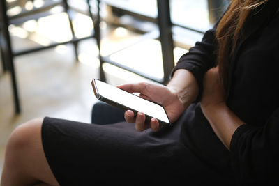 Midsection of woman using mobile phone