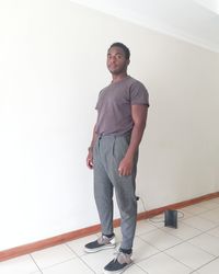 Portrait of young man standing against wall