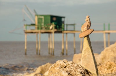 Close-up of rocks on beach and fishing hut in charente maritime