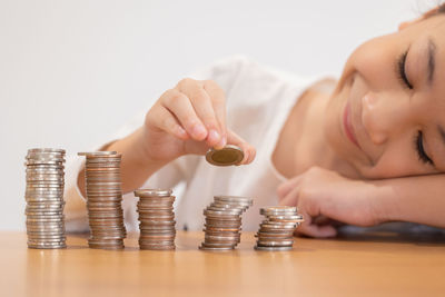 Midsection of woman stacking coins on table