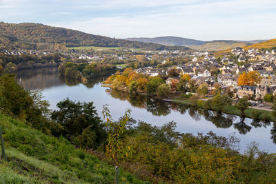 Scenic view of lake by townscape against sky