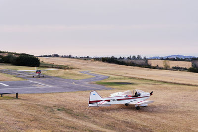 Airplane on airport runway against sky