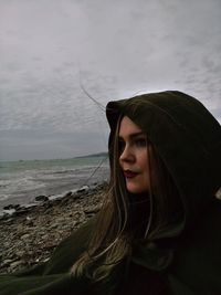 Young woman looking at sea against sky