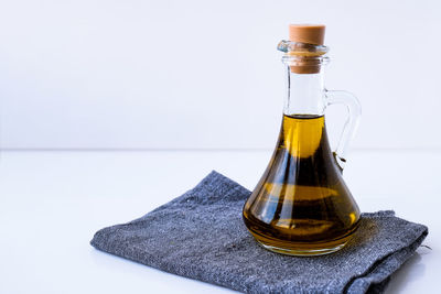 Close-up of glass bottle on table against white background