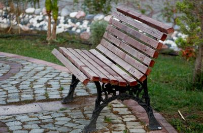 Empty bench in park during rainy season