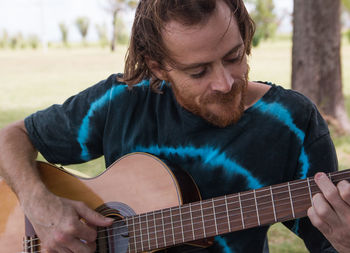 Bearded young man playing guitar