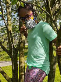 Full length of man standing by tree trunk