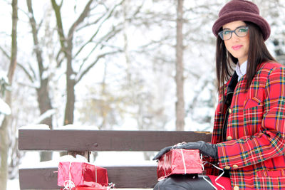 Portrait of young woman wearing hat against trees