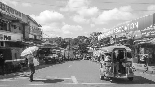 View of city street against cloudy sky